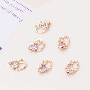 Macro detail of copper micro-set zircon heart and rose pendants in three colors for DIY jewelry
