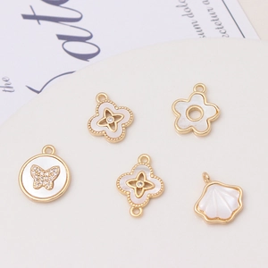 Five gold plated brass clover and shell pendants for DIY jewelry making and craft projects