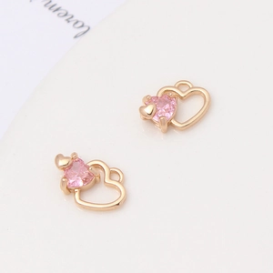 Detailed view of pink zircon heart pendants with gold frames for DIY jewelry making
