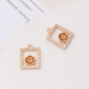 Detailed close-up of gold square pendants with zircon stones and 3D rose flower design