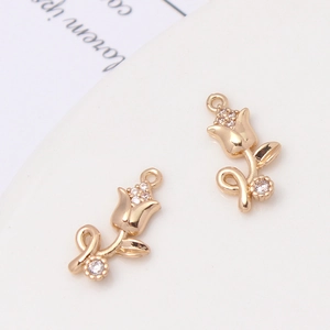 Detailed macro shot of golden tulip flower charms with sparkling zircon inlay for DIY jewelry