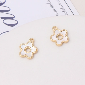 Detail shot of two gold-plated flower pendants with iridescent shell inlay for DIY jewelry