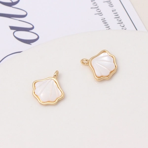 Macro detail of natural shell flower pendants with gold-plated frames for DIY jewelry