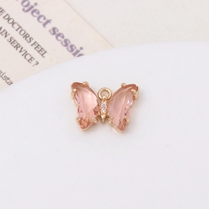 Détail macro d'un pendentif papillon rose avec dorure et zircons pour la création de bijoux DIY