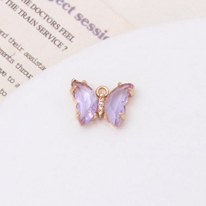 Détail d'un pendentif papillon en cristal violet avec dorure et zircons blancs