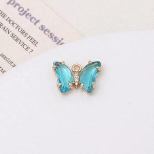 Macro d'un pendentif papillon en cristal bleu clair doré avec zircons cubiques