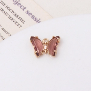 Vue macro d'un pendentif papillon doré rose avec cristaux violets et oxydes de zirconium