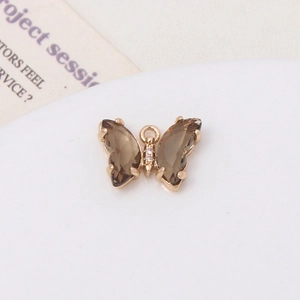 Détail d'un pendentif papillon doré orné de pierres brunes et de zircons brillants