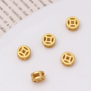 Detalle macro de cinco cuentas de oro mate con forma de moneda para joyería DIY