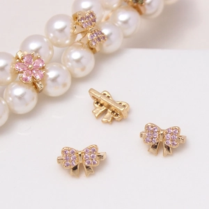Macro shot of gold-plated butterfly zircon spacer charms on a DIY pearl necklace