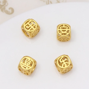 Vue macro de quatre breloques cubes dorés évidés avec caractères chinois porte-bonheur