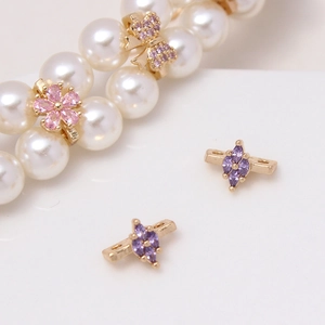 Macro detail of gold-plated flower and butterfly spacers with micro-set zircon for DIY jewelry