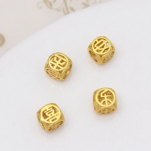 Gros plan de perles porte-bonheur dorées avec caractères chinois pour bijoux à faire soi-même