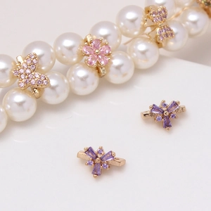 Macro view of gold jewelry spacer with butterfly and flower zircons on pearls