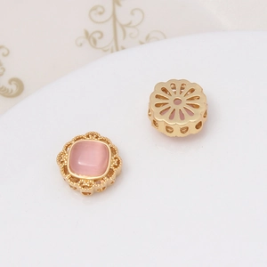 Λεπτομέρεια από χρυσά μενταγιόν λουλούδια με ροζ πέτρες για DIY κατασκευή κοσμημάτων