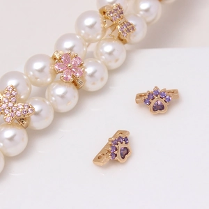 Detail of gold floral and butterfly spacer beads with micro-set zircon for DIY jewelry