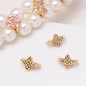 Macro detail of micro-pave zircon flower and star spacers for DIY jewelry making