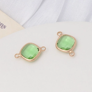 Macro de deux pendentifs en cristal vert avec cadres en or rose pour création de bijoux