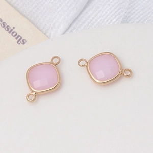 Détail de connecteurs en pierre rose à facettes avec anneaux dorés pour bijoux faits main