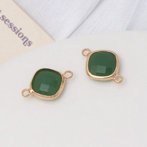 Détail de breloques en cristal facetté vert avec connecteurs dorés pour bijoux DIY