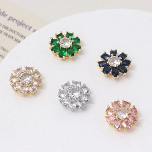Macro shot of colorful daisy flower zircon beads with golden and silver claw settings