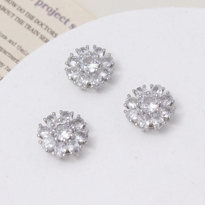 Macro detail of three daisy flower charms with sparkling zircon pavé for DIY jewelry