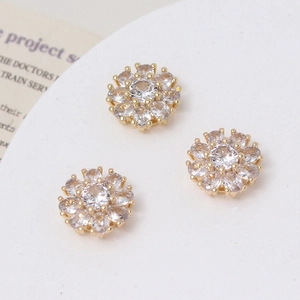 Macro detail of three daisy flower charms with sparkling zircons for jewelry making