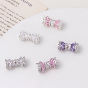 Macro shot of 14K zircon bow-shaped jewelry clasps in pink, white, and purple colors