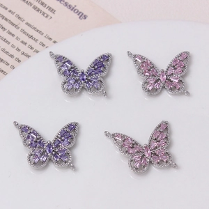 Vista detallada de dijes de mariposa 14K con cristales púrpuras y rosas para joyería DIY