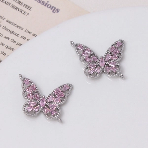 Vista detallada de conectores de mariposa plateados con circonitas rosas para joyería