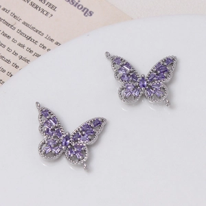 Vista macro de colgantes de mariposa huecos 14K con gemas violetas para joyería artesanal