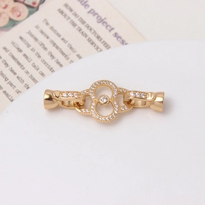 Vue détaillée du fermoir de collier de perles en or 14K avec zircons sur fond de papier