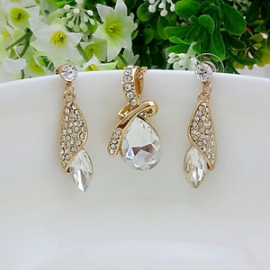 Elegantes vergoldetes Kristall-Schmuckset mit Strasssteinen in Birnenschliff und Blumenhintergrund