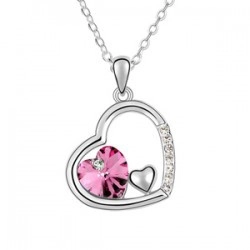 Détail du collier pendentif cœur avec cristal rose et pierres pavées sur fond blanc