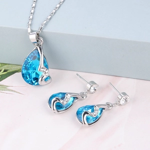 Detail van lichtblauwe druppelvormige sieradenset met ketting en oorbellen in zilverkleur