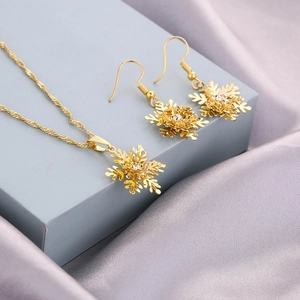 Elegantes Set aus goldener Schneeflocken-Halskette und passenden Hakenohrringen