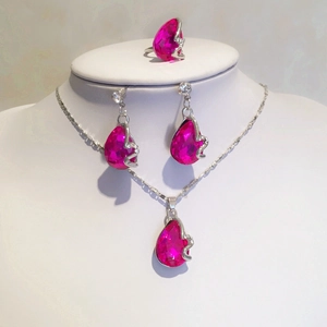 Detail van sieradenset met roze kristallen druppels, ketting, oorbellen en een ring