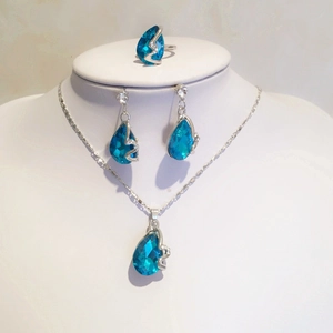 Detailweergave van blauwe druppelvormige kristallen sieradenset met ketting en ring