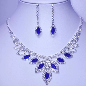 Macro shot of silver bridal necklace and earrings set with blue marquise crystals