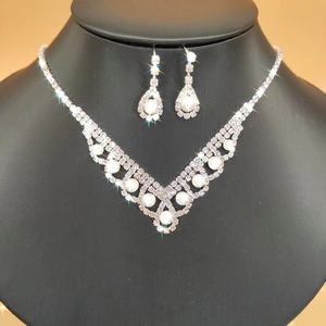 Bridal jewelry set with silver plating, sparkling rhinestones and white pearls on a model
