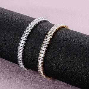 Primer plano de pulseras tenis doradas y plateadas con circonitas en expositor