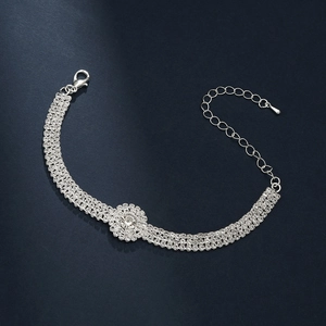 Détail du bracelet argenté orné d'une fleur en strass et d'un fermoir mousqueton réglable