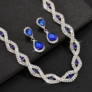 Detailopname van bruidssieradenset met blauwe peerkristallen en zilveren kwastjes