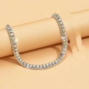 Detailed macro view of triple-row sparkling rhinestone necklace on silver-tone base