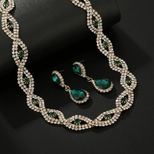 Gevlochten gouden ketting en oorbellen set met groene edelstenen en witte strass