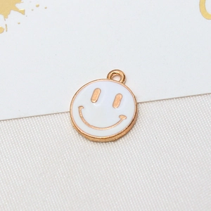 Macro shot of gold-plated smiley face pendant with white enamel for DIY jewelry