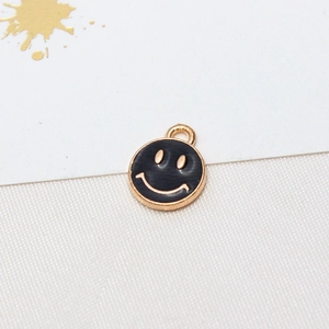 Detailed macro view of a round black and gold smiley face alloy charm pendant