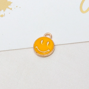 Detailed close-up of a yellow enamel smiley face pendant for DIY jewelry making