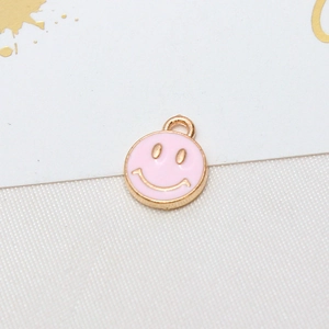 Close-up of pink enamel smiley face charm with gold trim for DIY earring jewelry making
