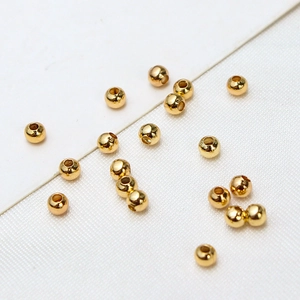 Macro view of polished 18K gold plated round copper spacer beads for jewelry making